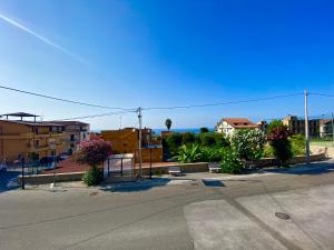 an empty street with buildings and the ocean in the background at Appartamento Orchidea in Parghelia +9 photos