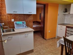 a kitchen with white cabinets and a sink at Apartments Jelena in Peroj