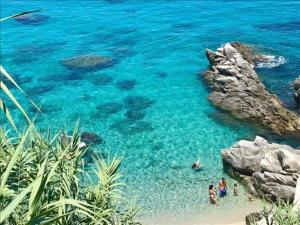 a group of people in the water at a beach at Appartamento Orchidea in Parghelia
