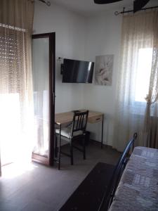 a room with a table and a chair and a desk at Primae Noctis Rooms in Roccascalegna