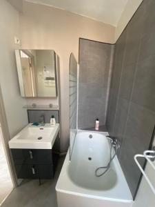 ein Badezimmer mit einer weißen Badewanne und einem Waschbecken in der Unterkunft Joli appartement entier T2 centre ville de Cherbourg in Cherbourg en Cotentin