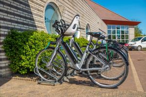 dos bicicletas están estacionadas frente a un edificio en Europarcs Ijsselmeer en Medemblik