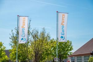 two flags on poles in front of a building at Europarcs Ijsselmeer in Medemblik