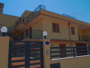 une maison avec un portail et un balcon dans l'établissement Don Turiddu, à Donnalucata