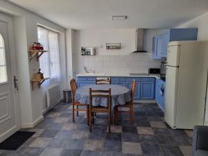 a kitchen with blue cabinets and a table and chairs at Maison de ville Ty Richarzh, 2 chambres, 4 personnes in Plouharnel