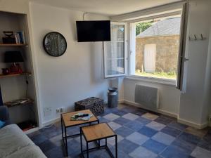 a living room with a couch and a clock on the wall at Maison de ville Ty Richarzh, 2 chambres, 4 personnes in Plouharnel