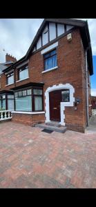 a brick house with a door and a brick driveway at Crumlin Road Town House in Belfast