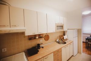 a kitchen with white cabinets and a sink at Apartman 4, Sinđelićeva 40 in Gornji Milanovac