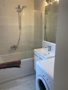 a bathroom with a washing machine and a sink at Superbe appartement climatisé avec parking privé in Port-Vendres