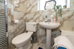 a bathroom with a toilet and a sink at 4 bedrooms,2 bathrooms house with free parking in Plumstead +57 photos