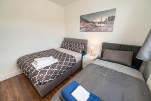 a bedroom with a bed and a twin bed at 4 bedrooms,2 bathrooms house with free parking in Plumstead