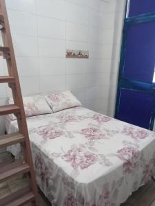 a small room with a bed with pink flowers on it at Trip Adventure Poa in Porto Alegre