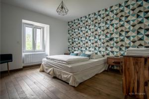 a bedroom with a bed and a geometric wall at Le Manoir, appartement Onyx in Le Bourg-dʼOisans