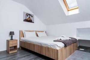 a bedroom with a bed and a night stand and a window at Agropensiunea Andrei & Ianis in Dăeşti