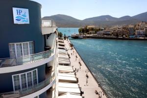 ein Gebäude neben einem Fluss, auf dessen Bürgersteig Menschen spazieren gehen. in der Unterkunft Paliria Hotel in Chalkida