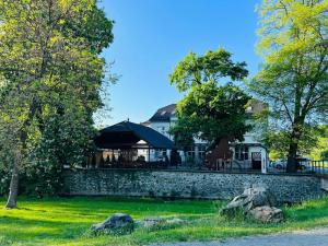 restauracja z kamienną ścianą i drzewami w obiekcie Penzion a Restaurace Bělecký Mlýn w mieście Ptení