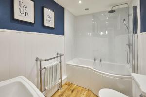 a white bathroom with a tub and a shower at Host & Stay - Sixpence Cottage in Pickering