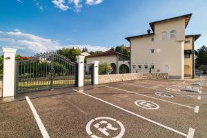 een parkeerplaats voor een gebouw met een poort bij TOSCANINA Garni Hotel in Dobrovo