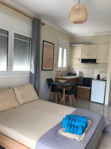 a bedroom with a large bed and a kitchen at georgia's cozy rooms #2 in Kavala +12 photos