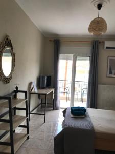 a bedroom with a bed and a desk and a window at georgia's cozy rooms #2 in Kavala