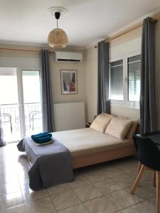 a bedroom with a large bed with windows at georgia's cozy rooms #2 in Kavala