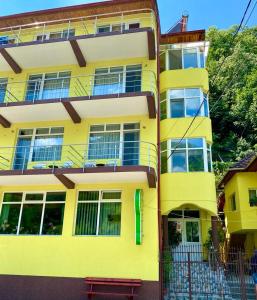 a yellow building with a bench in front of it at Pensiunea Argus in Băile Herculane