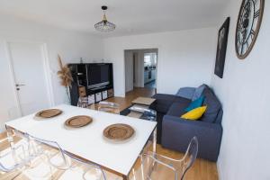 - un salon avec une table blanche et un canapé bleu dans l'établissement Spacieux appartement avec Balcons, 4 chambres, espace & confort, Centre Gare, à Rennes