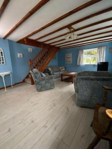 a living room with blue walls and wooden floors at The Coach House By The Sea in Mablethorpe