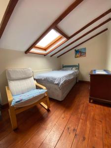 a bedroom with a bed and a chair and a window at The Coach House By The Sea in Mablethorpe