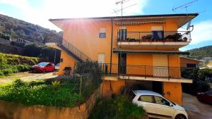 a yellow building with a car parked in front of it at CASA VACANZE My Way in Cavo