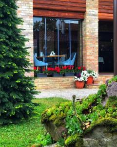 una casa con 2 sillas y una mesa con flores en Villa Diva, en Budureasa