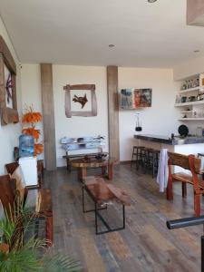 a living room with wooden floors and tables and chairs at Hotel Boutique Casa Mariano in Tepic