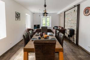 comedor y sala de estar con mesa y sillas en Le Manoir, appartement Onyx, en Le Bourg-dʼOisans