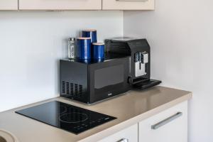 a kitchen counter with a coffee maker and a microwave at Rynek 45 Apartament in Wrocław