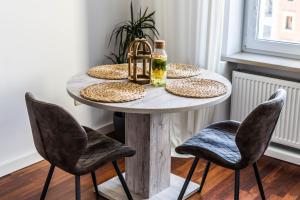 a table with plates and a bottle on top at Rynek 45 Apartament in Wrocław
