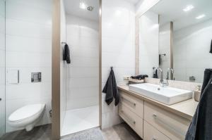 a white bathroom with a sink and a toilet at Rynek 45 Apartament in Wrocław