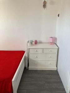 a bedroom with a bed and a dresser with a red blanket at T2 Cabourg - Résidence Le Sporting in Cabourg