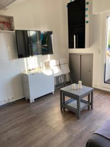 a living room with a table and a flat screen tv at T2 Cabourg - Résidence Le Sporting in Cabourg