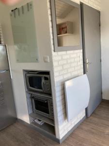a small kitchen with a microwave and a stove at T2 Cabourg - Résidence Le Sporting in Cabourg +3 photos