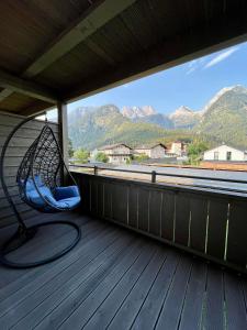 a rocking chair on a porch with a view of mountains at Christinenhof Top 5 mit großem Balkon in Lofer