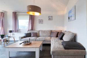 a living room with a couch and a table at Wattkueken in Simonsberg