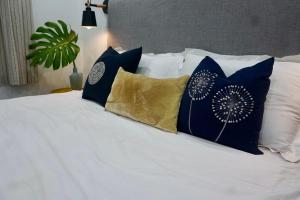 a bed with blue and white pillows on it at Papilio Homestay Tay Ho in Hanoi