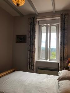 a bedroom with a bed and a window at La Verrerie de Guerlédan in Caurel