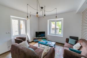 uma sala de estar com dois sofás e uma mesa em Le Manoir, appartement Onyx em Le Bourg-dʼOisans