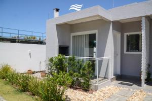 Casa blanca con puerta de cristal y balcón en CasaMar Pinheira, en Palhoça