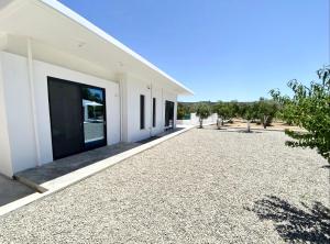 a white building with a gravel driveway at Lefko Apartments in Tavronitis