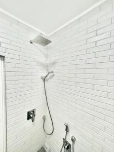 a shower in a bathroom with white brick walls at Joanna’s home in Veliko Tŭrnovo