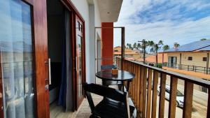 a balcony with a table and a view of a street at Pousada Sete Mares in Maragogi