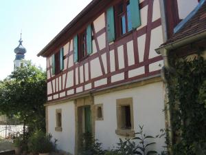 un edificio antiguo con ventanas verdes y una torre en Pilger- und Radlerherberge Herberge im Hofhaus, en Colmberg