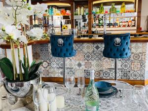 una mesa con sillas azules y vasos. en Entire Pub Sleeps up to 26 People Swansea - Your Own Pub Experience, en Swansea